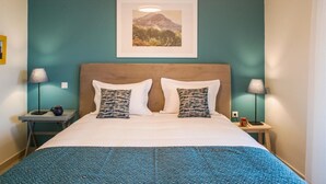 A hotel room with a bed, two nightstands, a framed picture on the wall, and a window. - Anemi  Apartments  II (Nafplio)