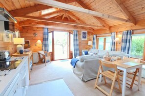 Un intérieur de chalet chaleureux et accueillant, comprenant une cuisine, un coin repas et un canapé.