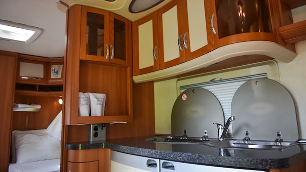 A compact kitchen with wooden cabinets, a countertop, and a sink. - Big Game on Wheels - Wilpattu (Pahala Maragahawewa)
