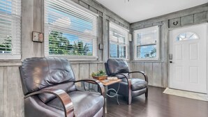 A room with two leather chairs, a small table, and a white door. - 1 Step Closer 2 Bedroom Villa by RedAwning (Holmes Beach)