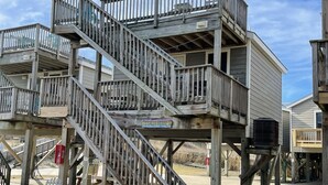 A wooden multi-level structure with a staircase, benches, and a sign. - 19 Oceans Door West Studio Bedroom Condo by RedAwning (Hatteras)
