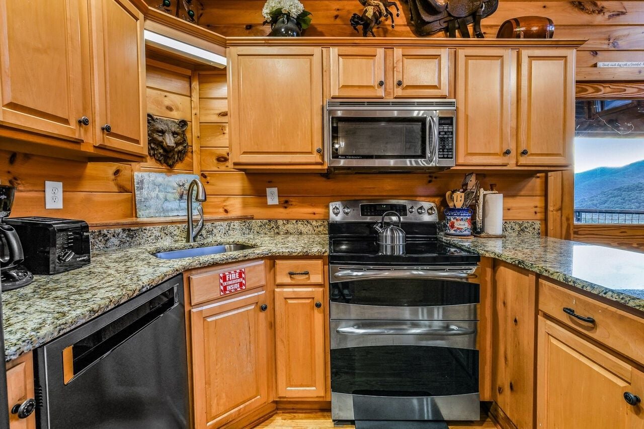 A kitchen with wooden cabinets, a microwave, an oven, a toaster, and a sink.