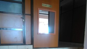 Un salón de negocios con un banco, piso de baldosas y un cartel que indica el área del salón.