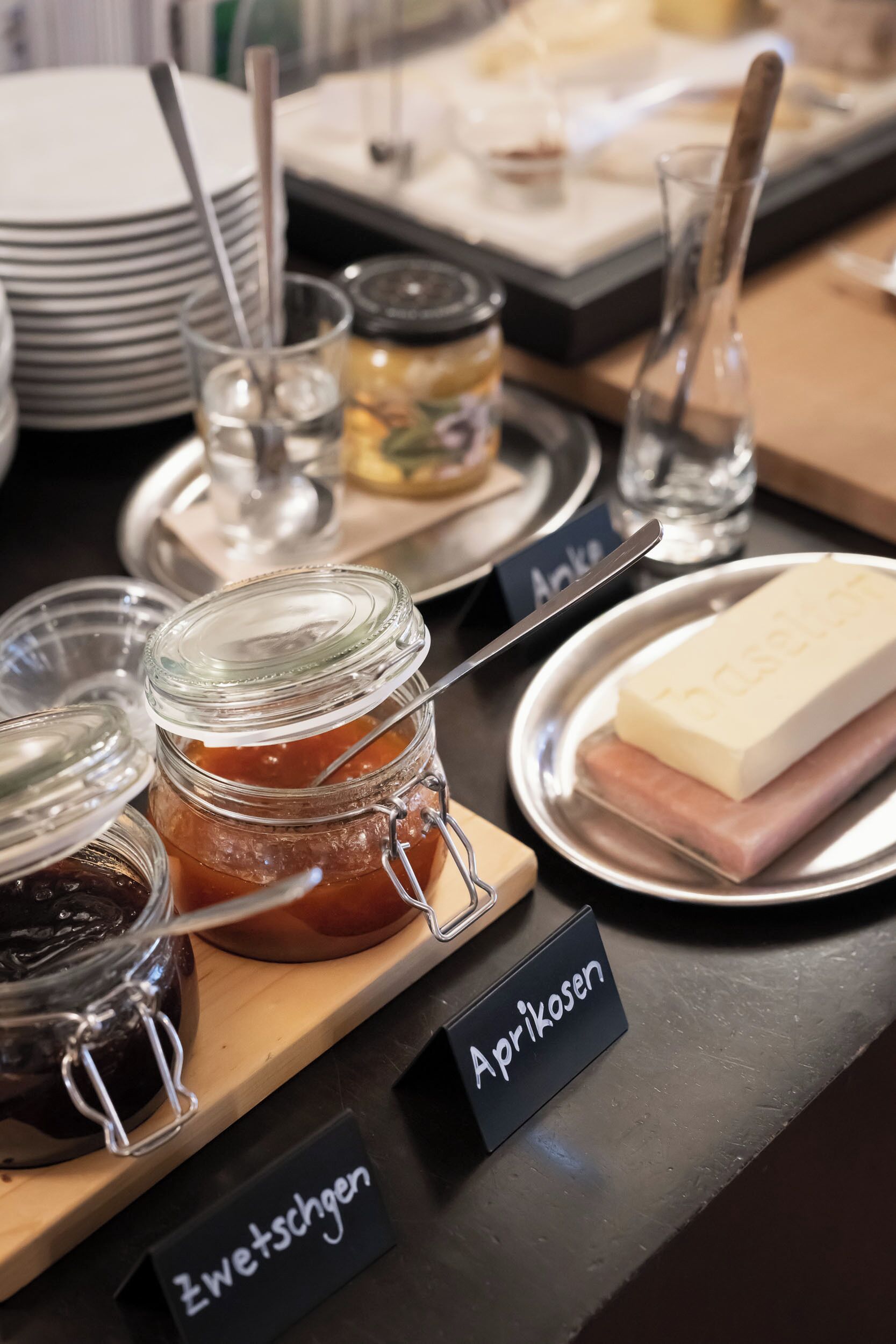 A buffet table with labeled dishes, including apricot and zwetschgen.