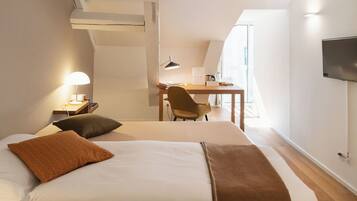 Habitación de hotel con una cama, un escritorio, una silla, un televisor y una ventana.