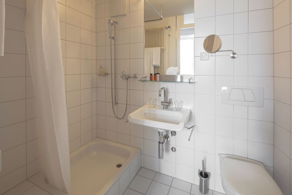 Un baño moderno con bañera, ducha, lavabo e inodoro.