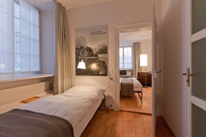 A hotel room with a bed, a desk, a chair, and a window. - Hotel Baseltor (Solothurn)