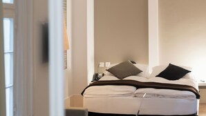 Una camera da letto con un letto, un comodino, una sedia e vista sull'esterno.