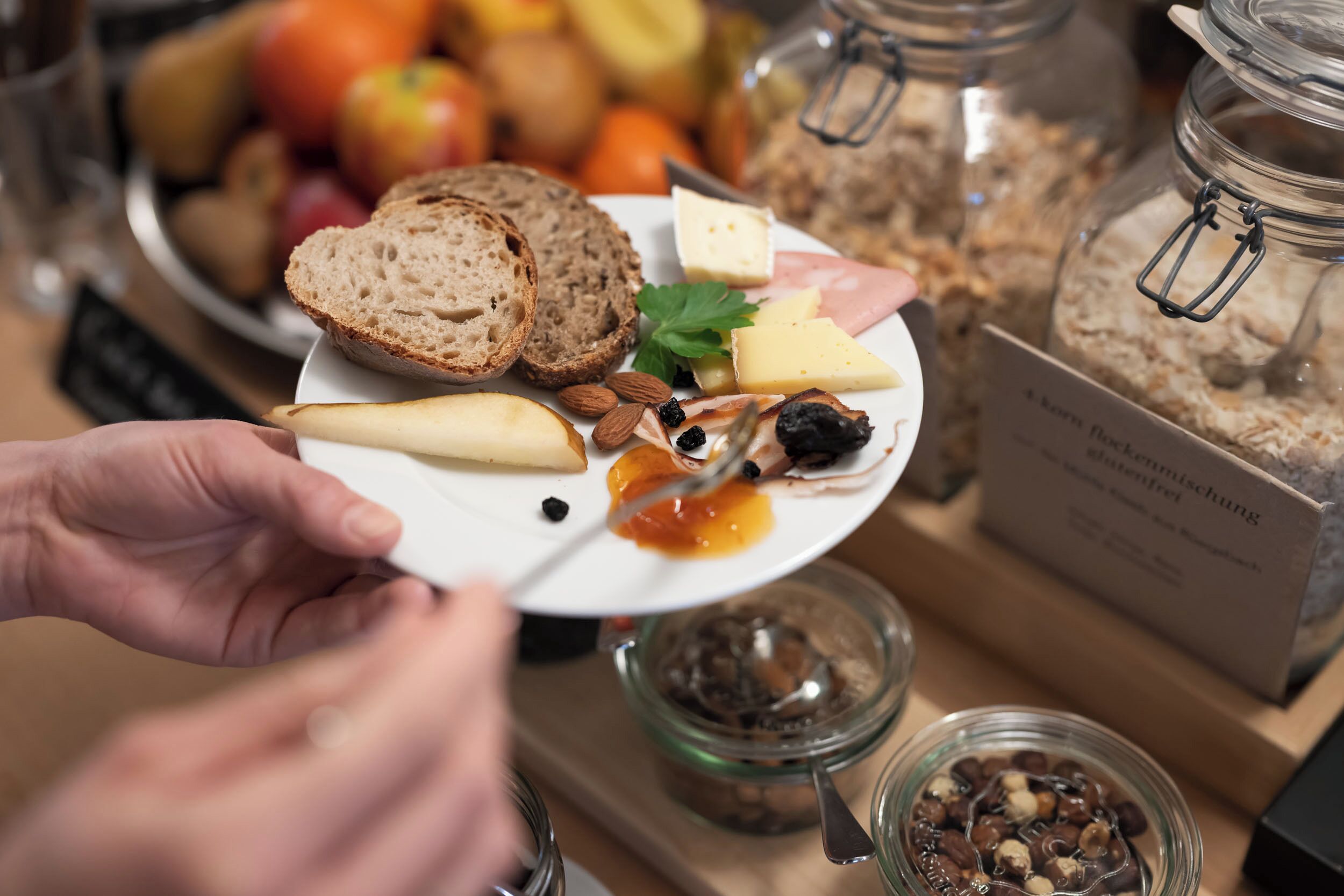 A plate with cheese, bread, and nuts.