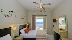 A hotel room with a bed, bedside table, nightstand, desk, and a large mirror. - Pension Votsi (Alonissos)