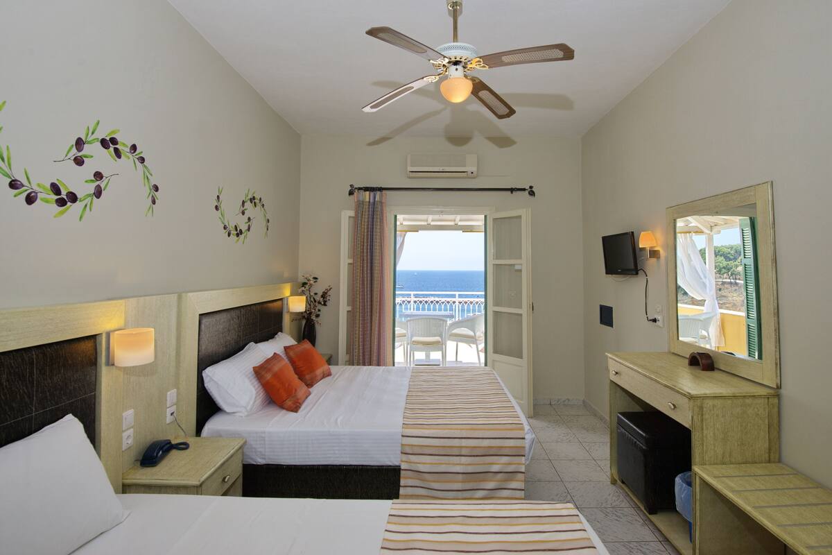 A hotel room with a bed, bedside table, nightstand, desk, and a large mirror.