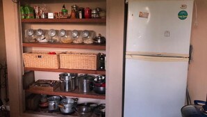 A kitchen with shelves holding jars, baskets, and pots. - 2 bedroom house in toledo (Toledo)