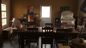 A dining area with a large wooden table and chairs, a window with blinds, and a door. - 2 bedroom house in toledo (Toledo)