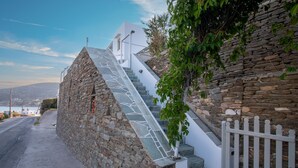 A stone staircase leading to a white building with a view of the sea. - Prasini Gonia (Sifnos)
