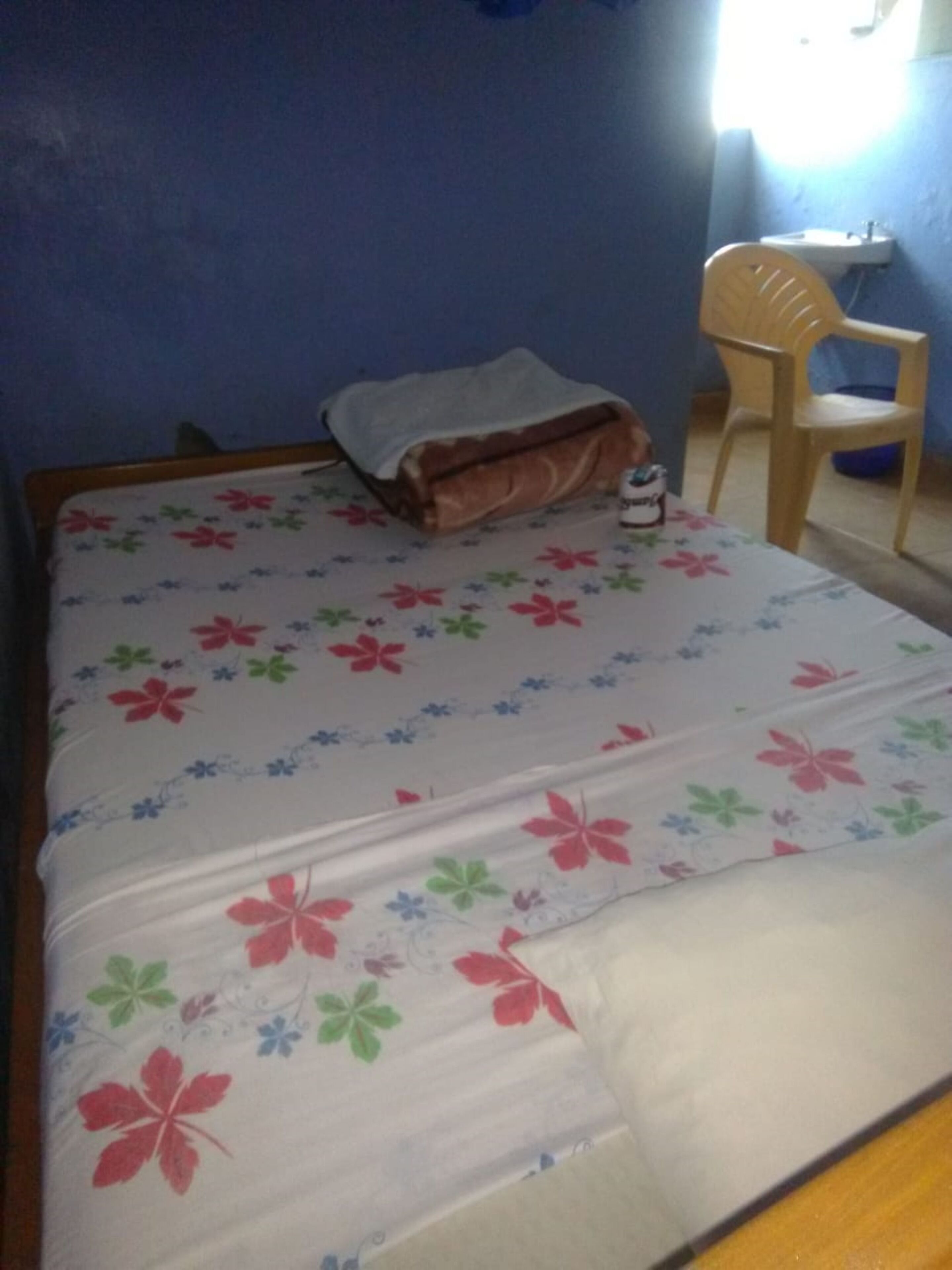 Ein Schlafzimmer mit einem Bett, einem Sessel und einem kleinen Tisch.