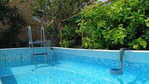 A swimming pool with a tiled floor and a ladder. - Appartamento le Campanelle (San Felice del Benaco)