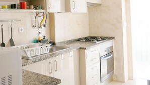 Una cocina moderna con armarios blancos, encimera de granito y electrodomésticos de acero inoxidable.