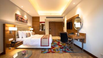 Ein Hotelzimmer mit Bett, Nachttisch, Schreibtisch, Stuhl und Spiegel.