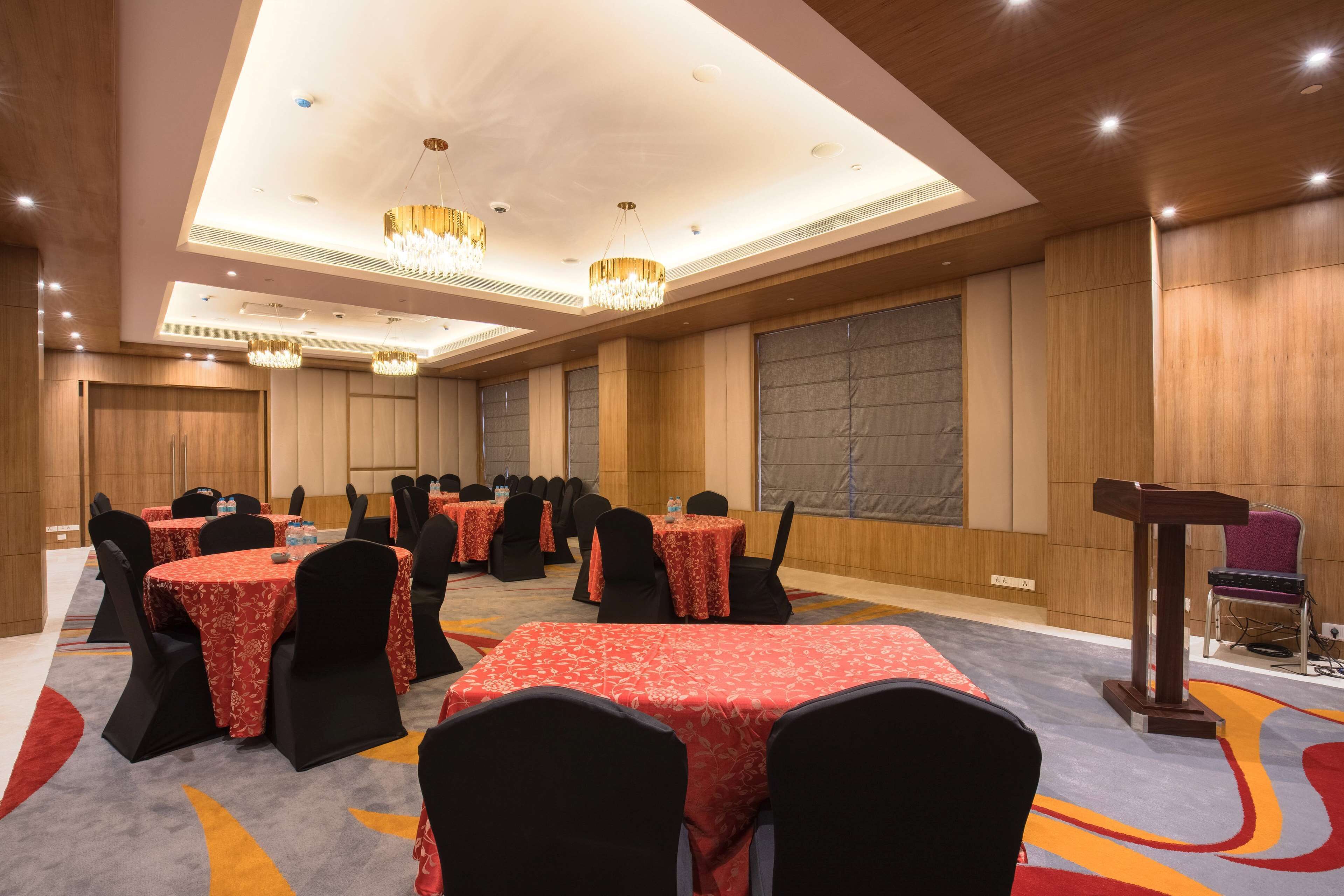 A conference room with round tables, black chairs, and a podium.
