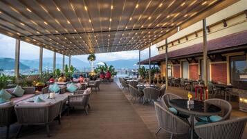 An outdoor seating area with wicker furniture and a view of the city.