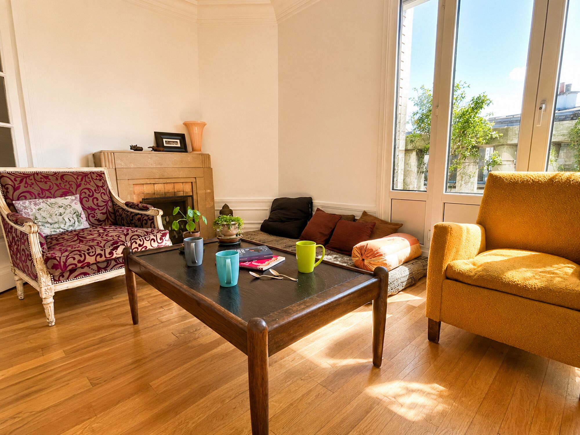 Una sala de estar con chimenea, un sofá, una mesa de centro y un ventanal con vistas al exterior.
