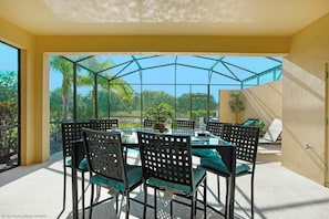 A sunlit patio with a glass enclosure, featuring a table with chairs and a potted plant. - Enjoy the Private View! Roomy Town Home With Pool, 20 Mins From Disney #5st739 (Davenport)