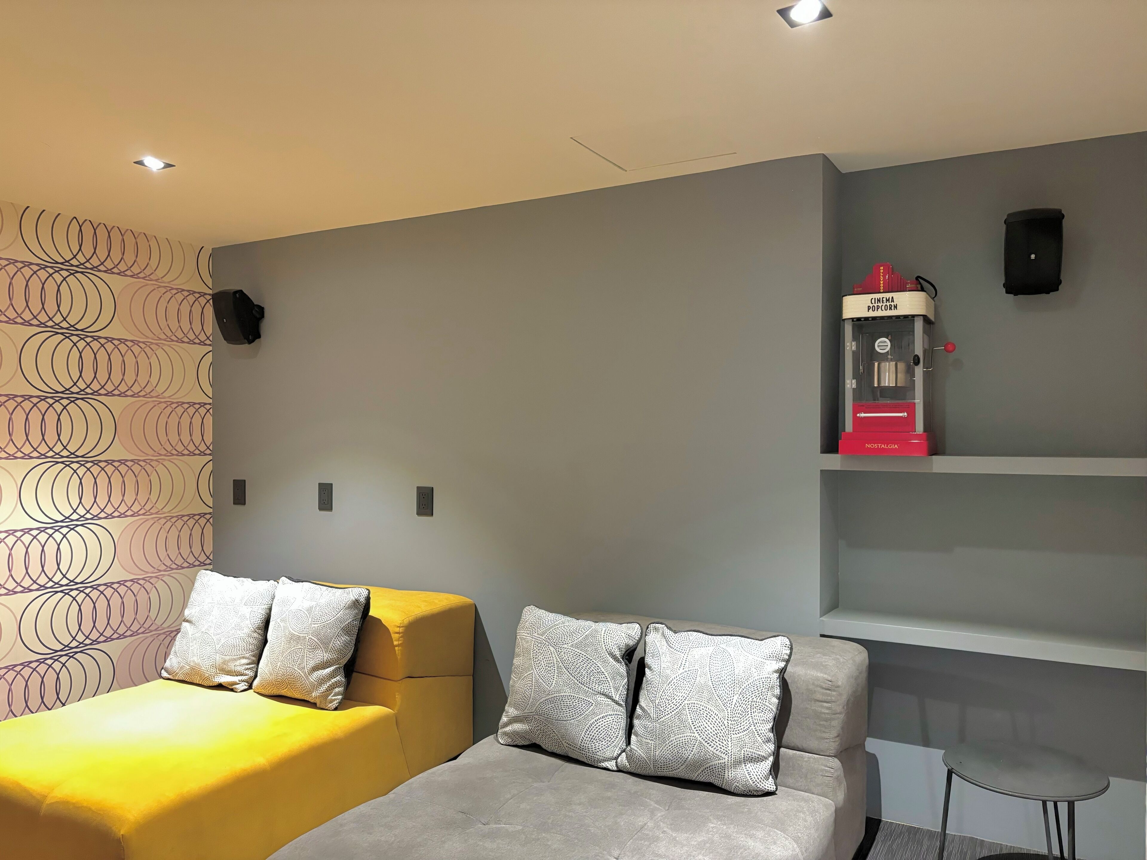 A hotel room with two beds, a cinema popcorn machine, and a small table.