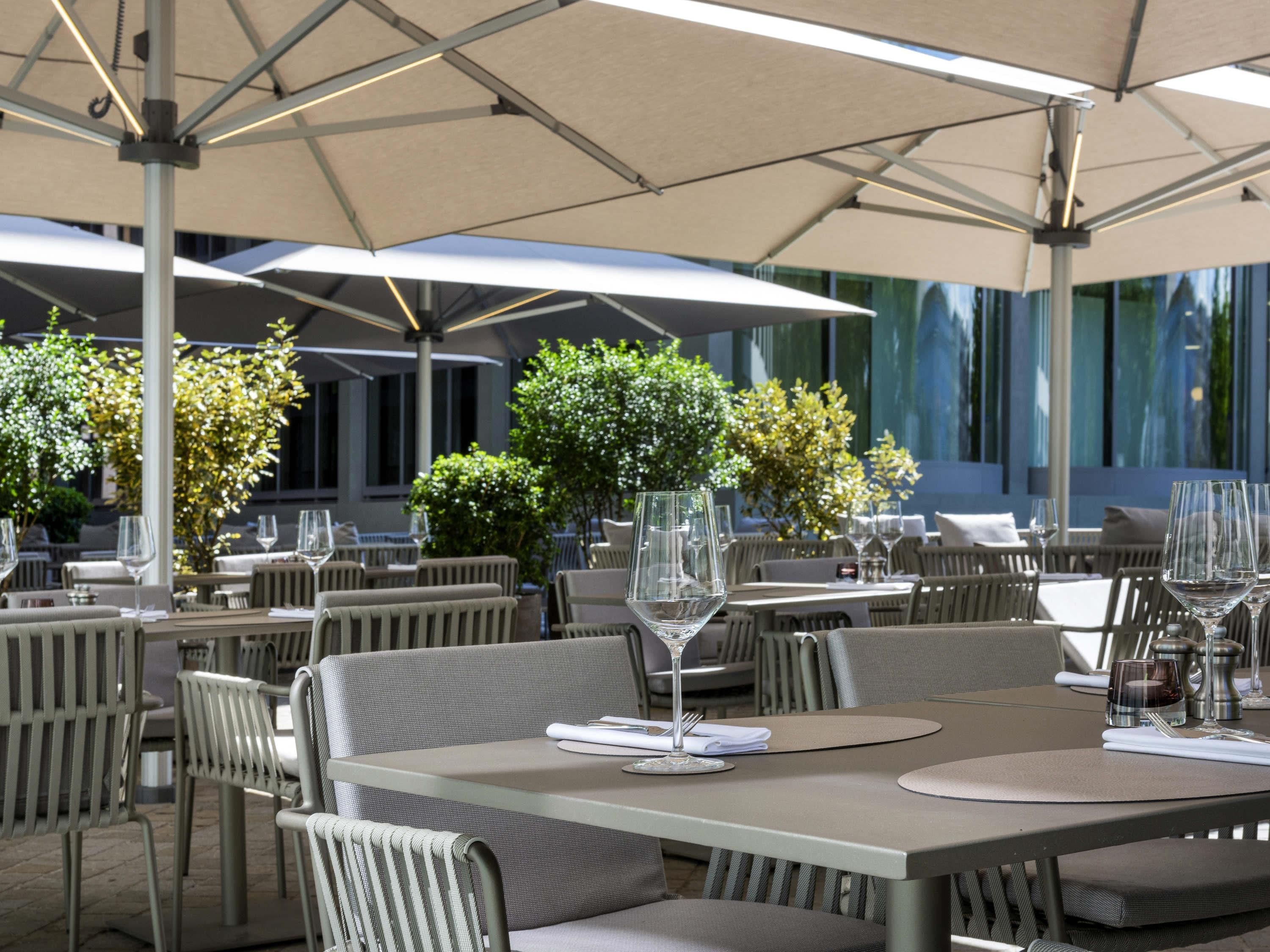 An outdoor dining area with tables, chairs, and umbrellas.