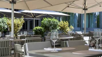 An outdoor dining area with tables, chairs, and umbrellas.