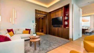 Una sala moderna con un sofá, una mesa de centro y un televisor de pantalla plana montado en una pared de madera.