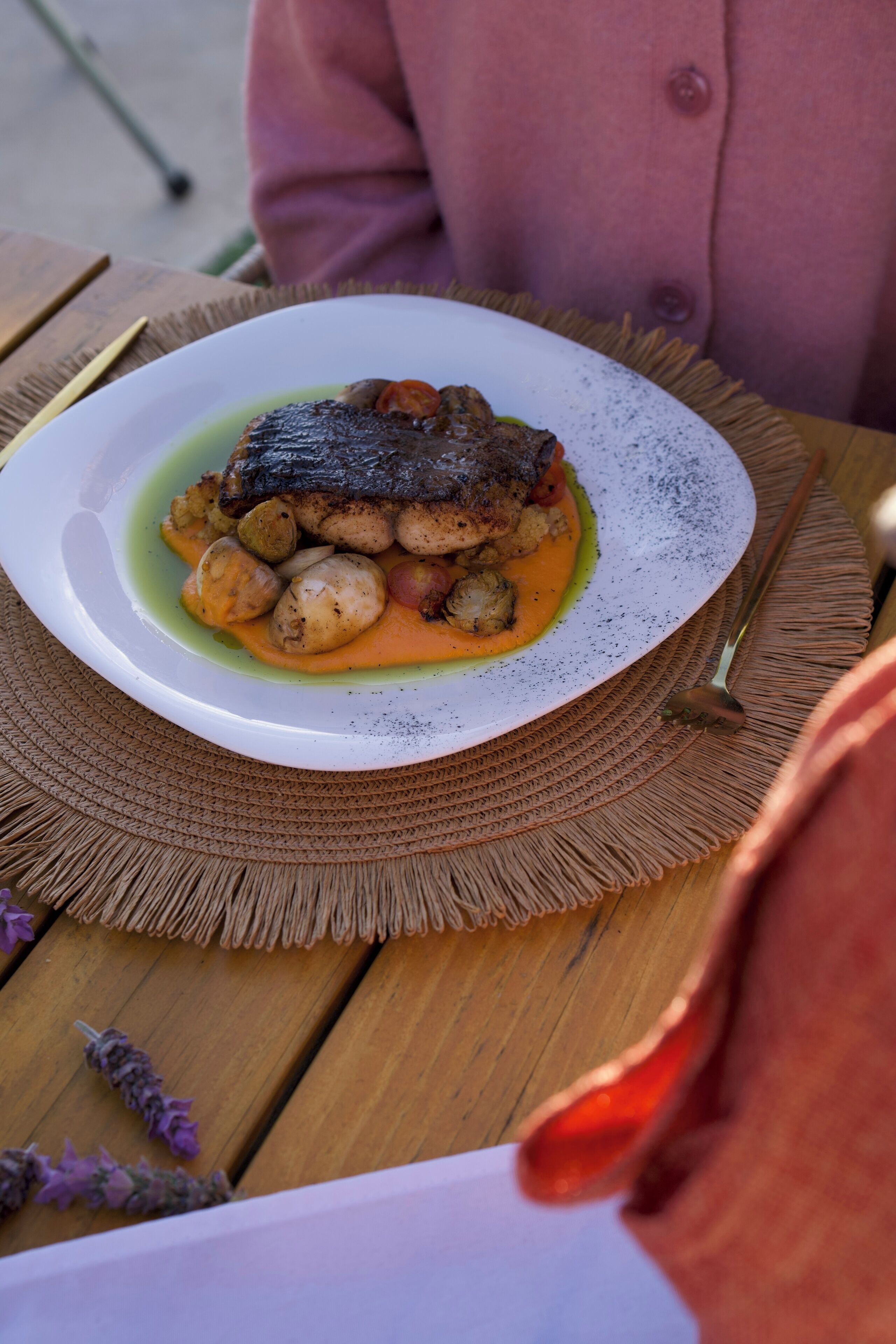 Un plato de comida sobre una mesa con un posavasos tejido.