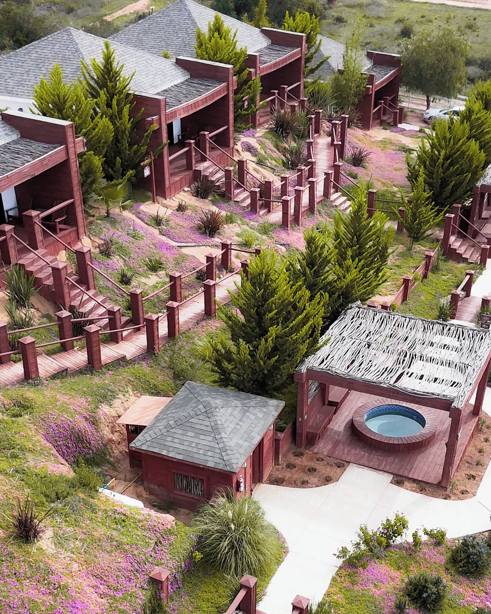 A residential complex with multiple buildings, a central courtyard with a swimming pool, and surrounding landscaped gardens.