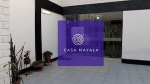 Ein moderner Gebäudeeingang mit einem violetten Schild für CASA MAYALA in San Bartolomé, Peru.