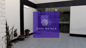 En modern entré till en byggnad med en lila skylt som visar namnet CASA MAYALA, i San Bartolomé, Peru.