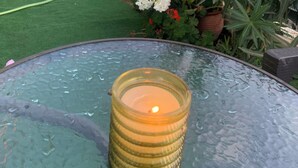 A glass table with a candle in a glass holder. - Villa Olympia Skafidia beach (Skafidia Pirgos ilias)