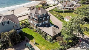 Un área residencial costera con casas, una playa y una vista despejada del océano.