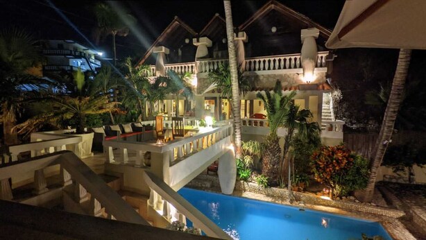 A hotel with a pool, outdoor seating, and a well-lit patio area. - Ecolodge Vistamar (Enriquillo)