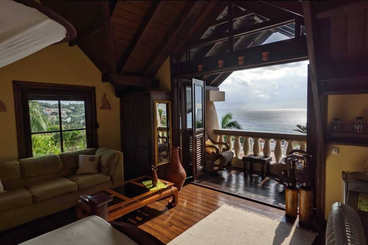 Ein gemütliches Wohnzimmer mit einer Couch, einem Couchtisch und Meerblick vom Balkon.