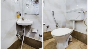 A bathroom with a white sink, mirror, and toilet. - Shri Sai Residency (Jaipur)