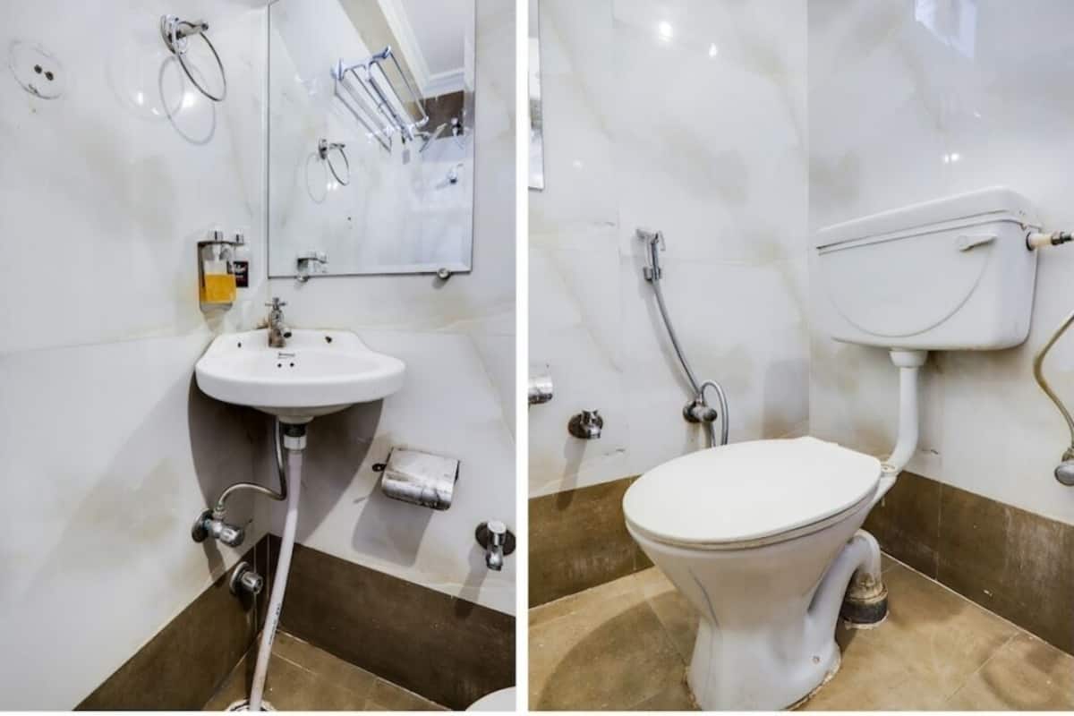 Un baño con lavamanos, espejo y retrete.