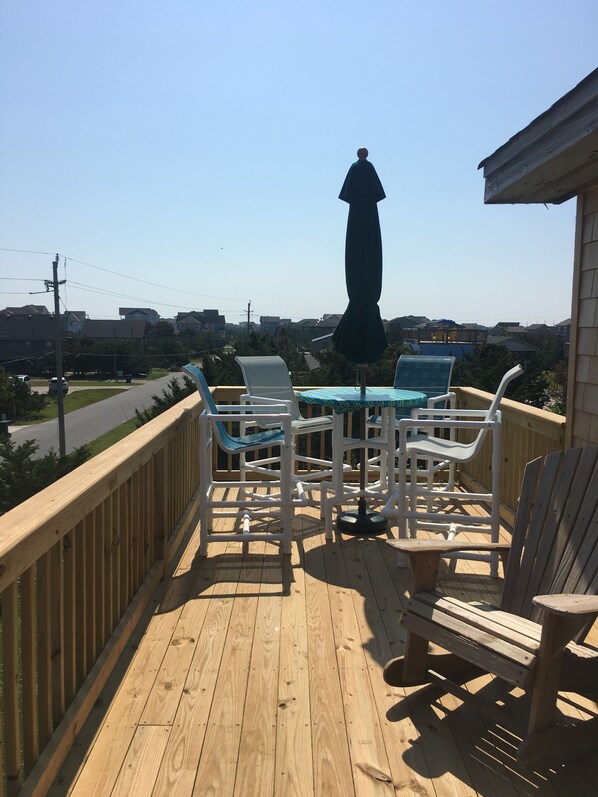 Enjoy an outdoor space with a view of the surrounding neighborhood from this deck, featuring a table and chairs.