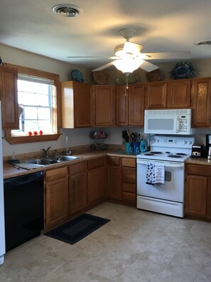 Enjoy cooking in this well-equipped kitchen with a central island, microwave, stove, and dishwasher.