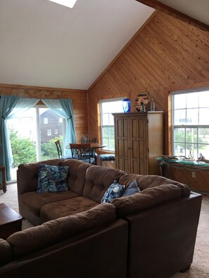 Relax in this serene living room with a sofa, dining table, and cabinet, offering a peaceful view.