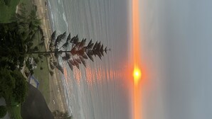 A sunset over a beach with palm trees and a clear sky. - MASSIVE 7 BEDROOM MALECON DUPLEX PENTHOUSE (Urb Santa Cruz)