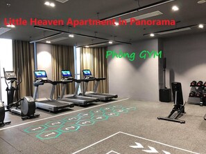 Une salle de sport équipée de tapis de course, d’un vélo d’appartement et d’un sac de frappe.