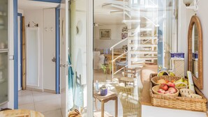 A modern interior with a staircase, a dining area with wicker furniture, and a kitchen visible through a glass door. - Appt With Garden Near Jardin Du Luxembourg (Paris)
