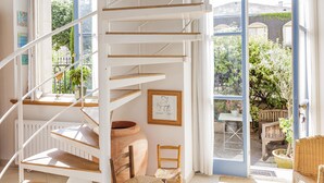 A spiral staircase with white railings and wooden steps, leading to a balcony with a view of greenery and a building. - Appt With Garden Near Jardin Du Luxembourg (Paris)