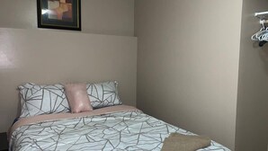 A bedroom with a bed, pillows, a blanket, and a framed picture on the wall. - FLEETWOOD :1 Bedroom Space B1 (Fort McMurray)