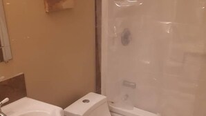 Un baño con lavamanos, inodoro y cabina de ducha blancos.