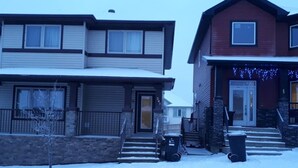 A residential area with two houses, one with a garage and the other with a front porch.
